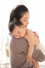 Jung chinesisch mutter holding sie schlafen baby — Stockfoto