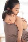 Jeune maman chinoise tenant son bébé endormi — Photo de stock
