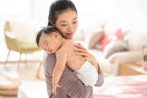 Giovane mamma cinese che tiene il suo bambino addormentato — Foto stock