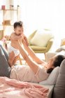Mère et bébé jouer et rire sur le canapé — Photo de stock