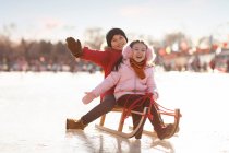 Joyeux chinois traîneau de frères et sœurs à l'extérieur — Photo de stock