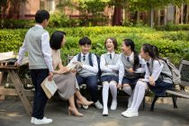 Китайська вчителька розмовляє зі студентами в кампусі. — стокове фото