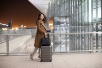 Junge Frau läuft mit Gepäck in Flughafen — Stockfoto