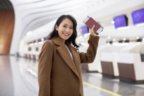 Mujer feliz con pasaporte y billete de avión en el aeropuerto - foto de stock