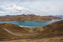 Lago Yamdrok con colinas y cielo nublado en el Tíbet, China - foto de stock