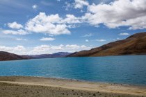 Lago di Yamdrok con colline e cielo nuvoloso in Tibet, Cina — Foto stock