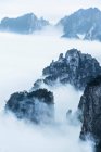 Rocce circondate da basse nuvole, Huangshan, Cina — Foto stock