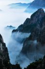 Felsen mit Bäumen und niedrigen Wolken, Huangshan, China — Stockfoto