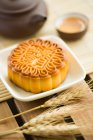 Mooncake chinês tradicional com espiguetas na mesa — Fotografia de Stock