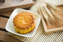 Pastel de luna tradicional chino en plato de madera - foto de stock