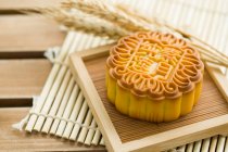 Pastel de luna tradicional chino en plato de madera - foto de stock