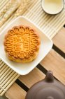 Mooncake, teapot and tea in cup on table — Stock Photo