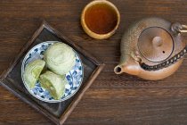 Matcha crisp desserts and tea in pot and cup — Stock Photo