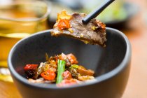 Китайское блюдо, говядина с перцем чили в миске и палочки для еды — стоковое фото