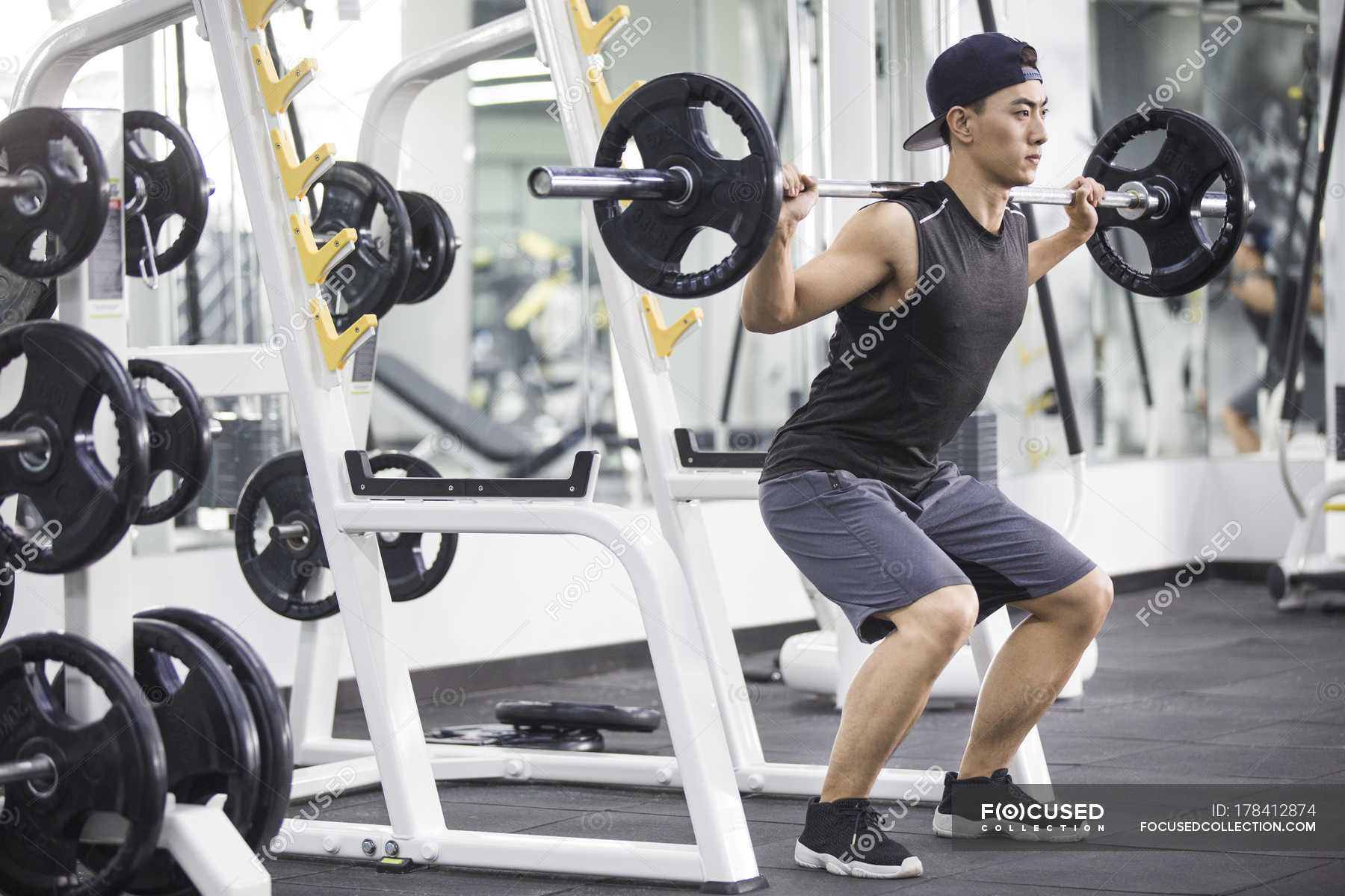 Asian man lifting barbells at gym — practicing, strength - Stock Photo