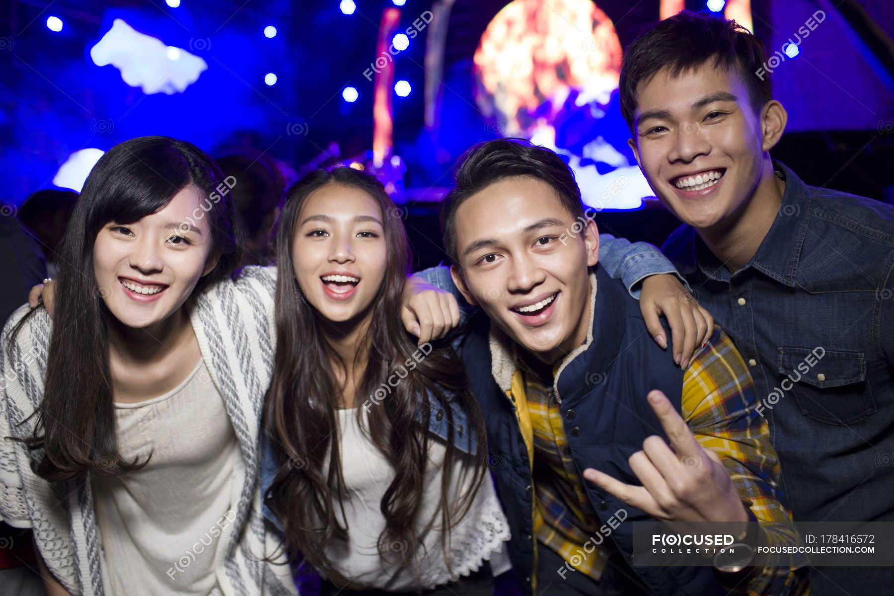 Chinese friends embracing and gesturing at music festival — nightlife ...