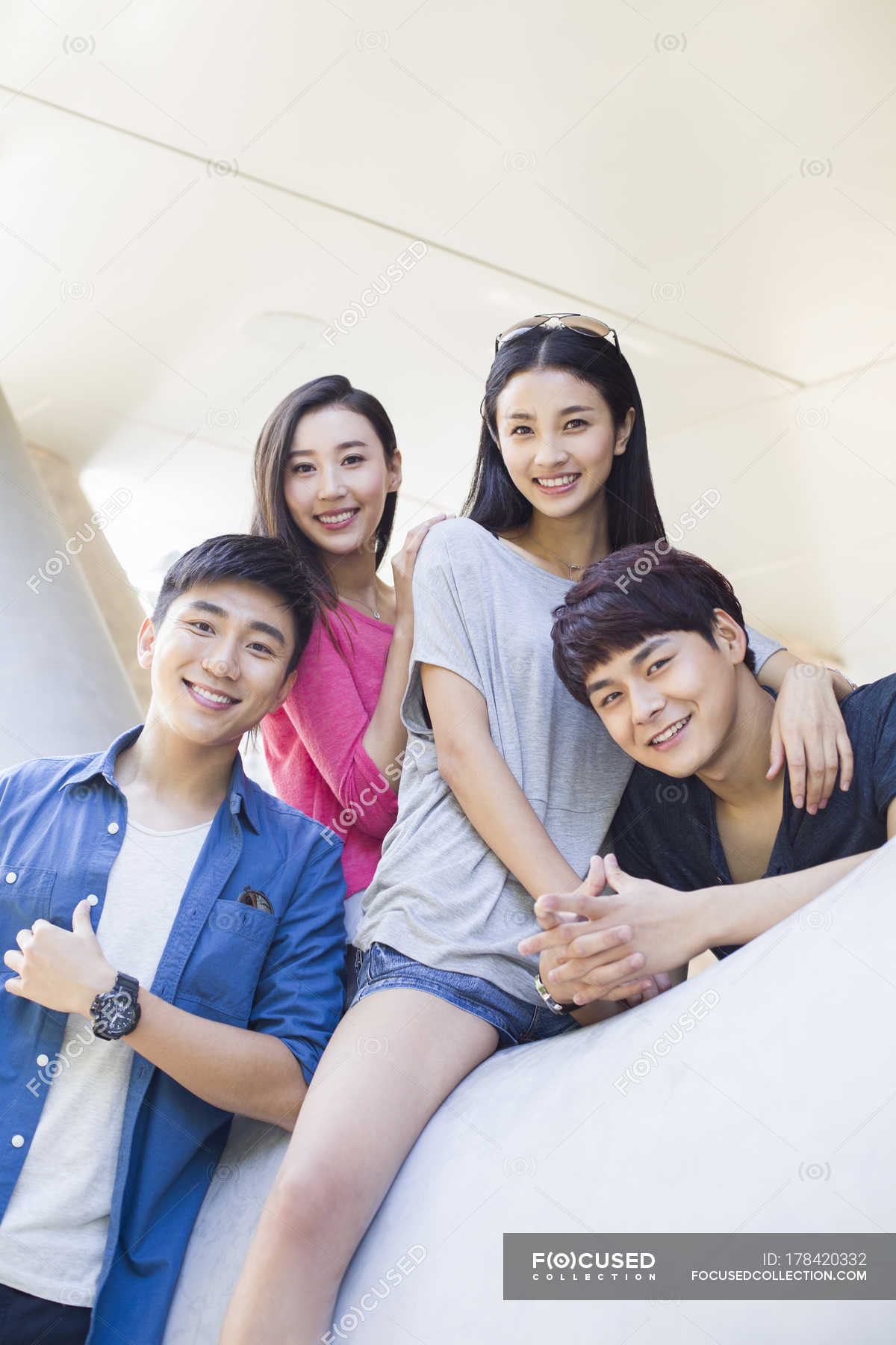 Chinese friends sitting in building and looking in camera — female ...