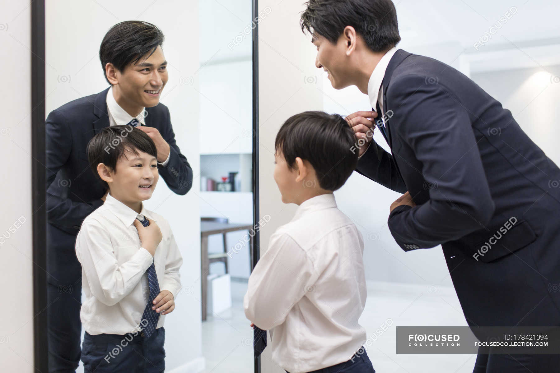 Chinese father and son adjusting ties in morning � people, man