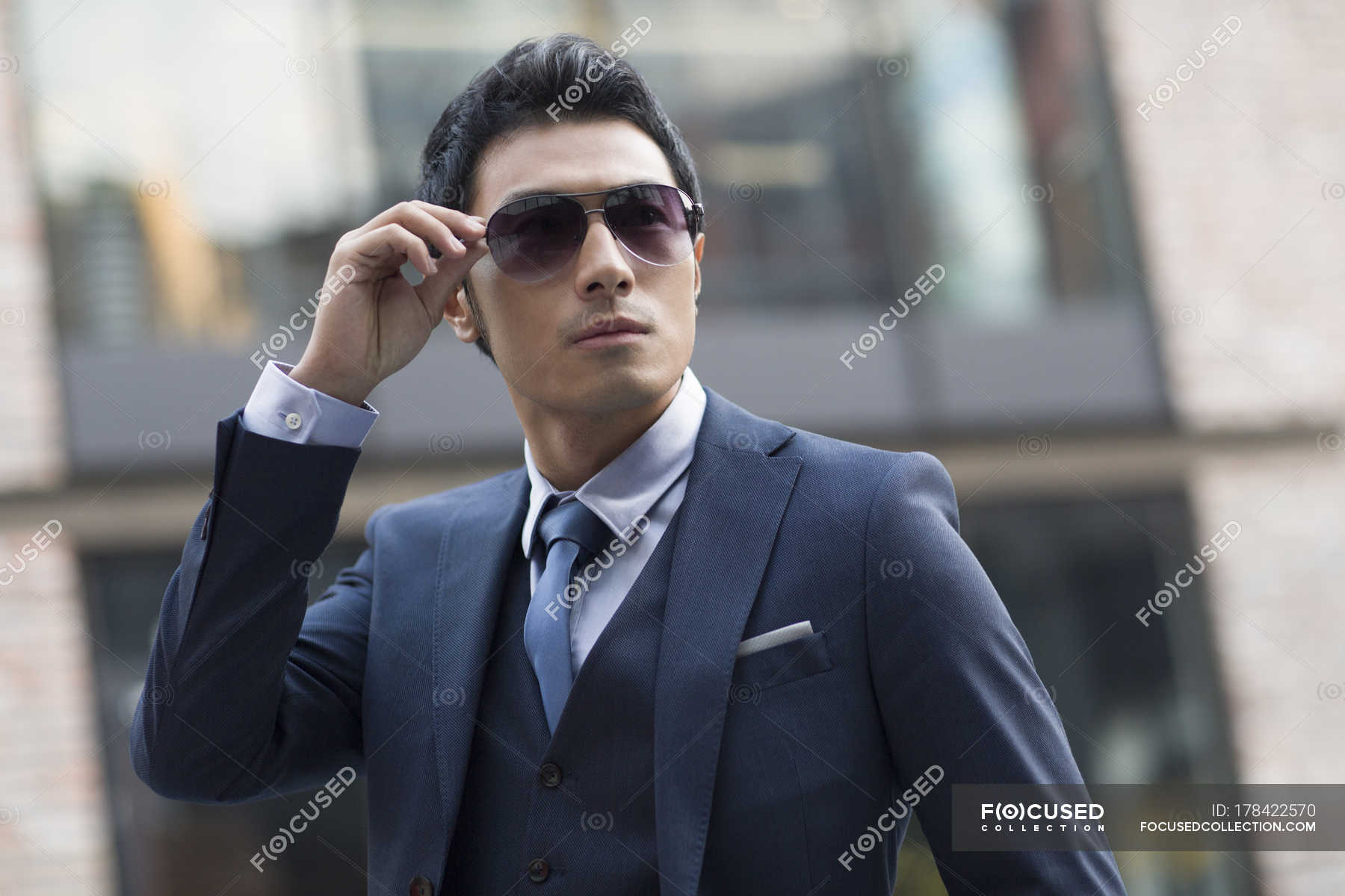 Focused 178422570 Stock Photo Asian Man Putting Sunglasses Urban 