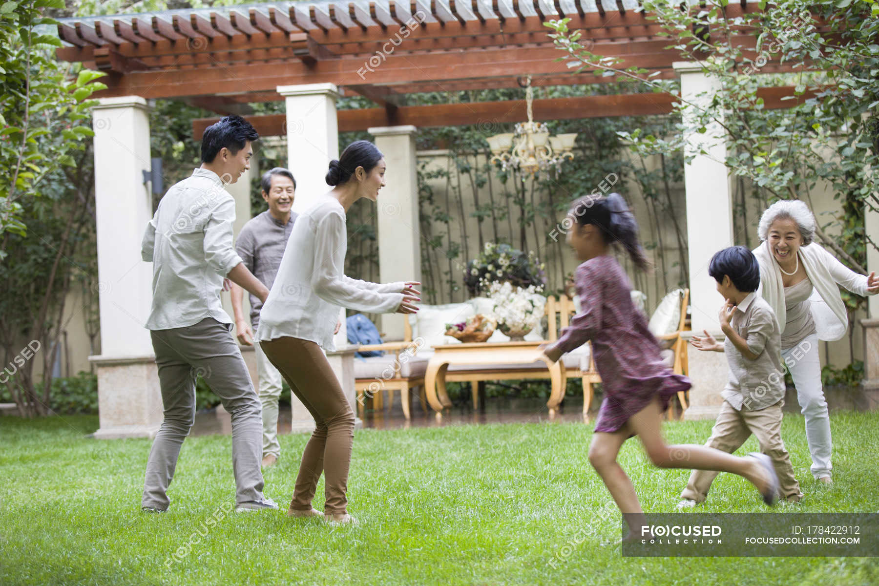 Happy Chinese Multi Generation Family Playing Together In Garden
