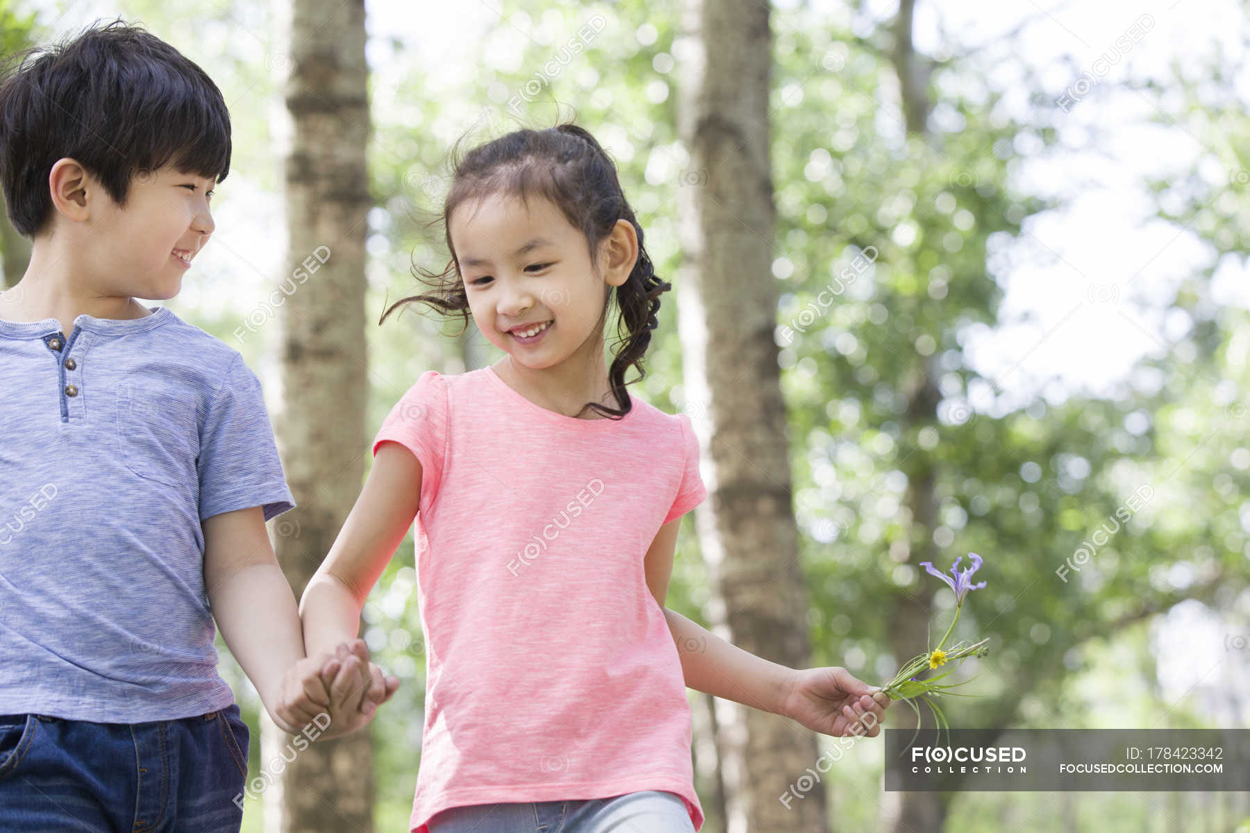 Chinese Boy And Girl Holding Hands Walking In Woods Forest Friendship Stock Photo