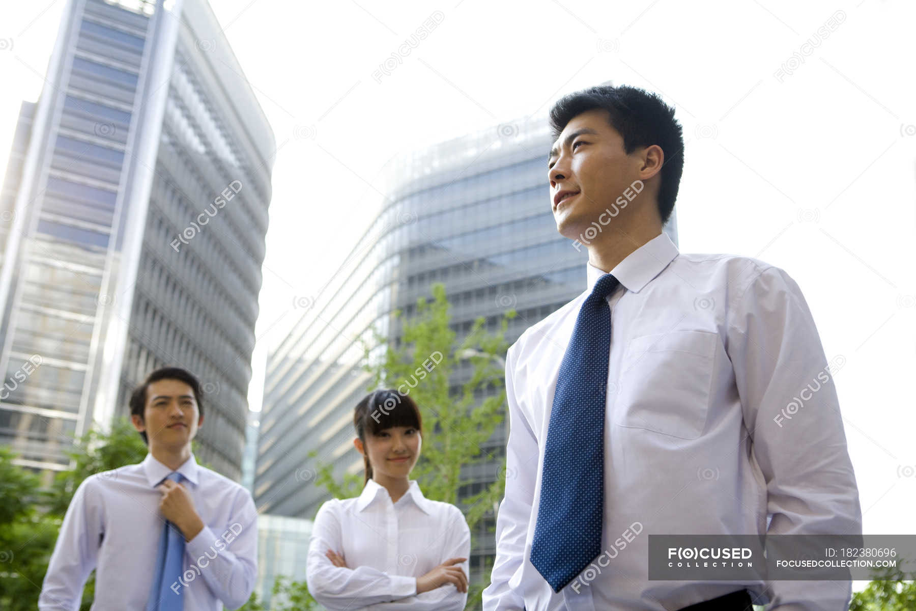 Chinese office workers standing in front of skyscrapers — white collar ...