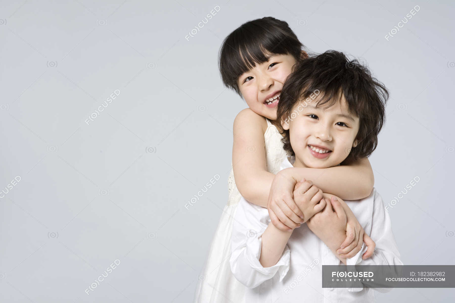 Asian brother and sister embracing on gray background — Elementary Age,  Waist Up - Stock Photo | #182382982