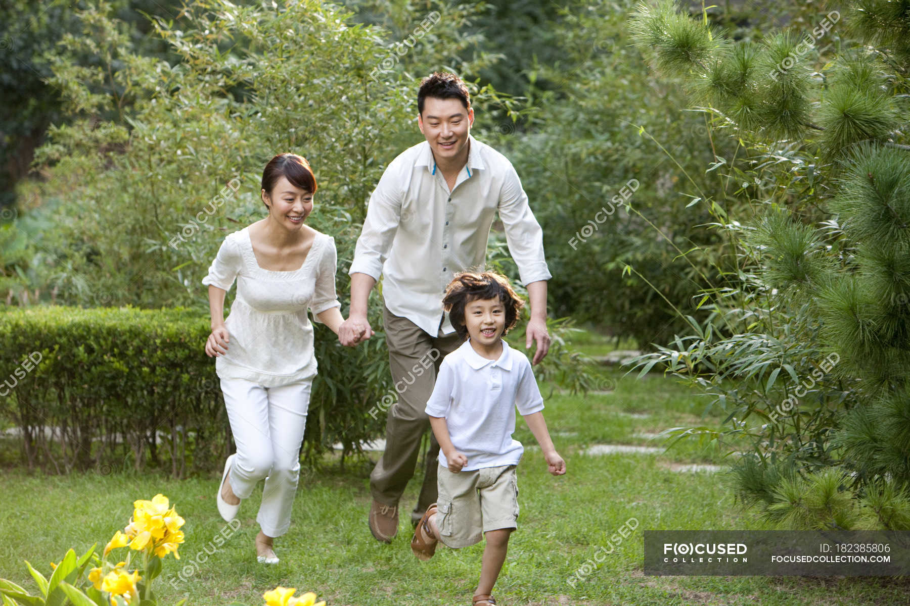 Chinese Family Running And Having Fun In Garden Summer People