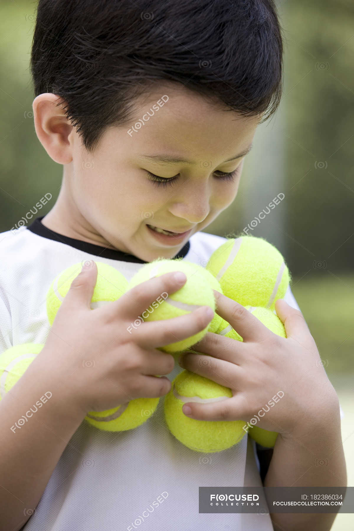 Portrait Of Little Chinese Boy Holding Tennis Balls Fun Cheerful Stock Photo