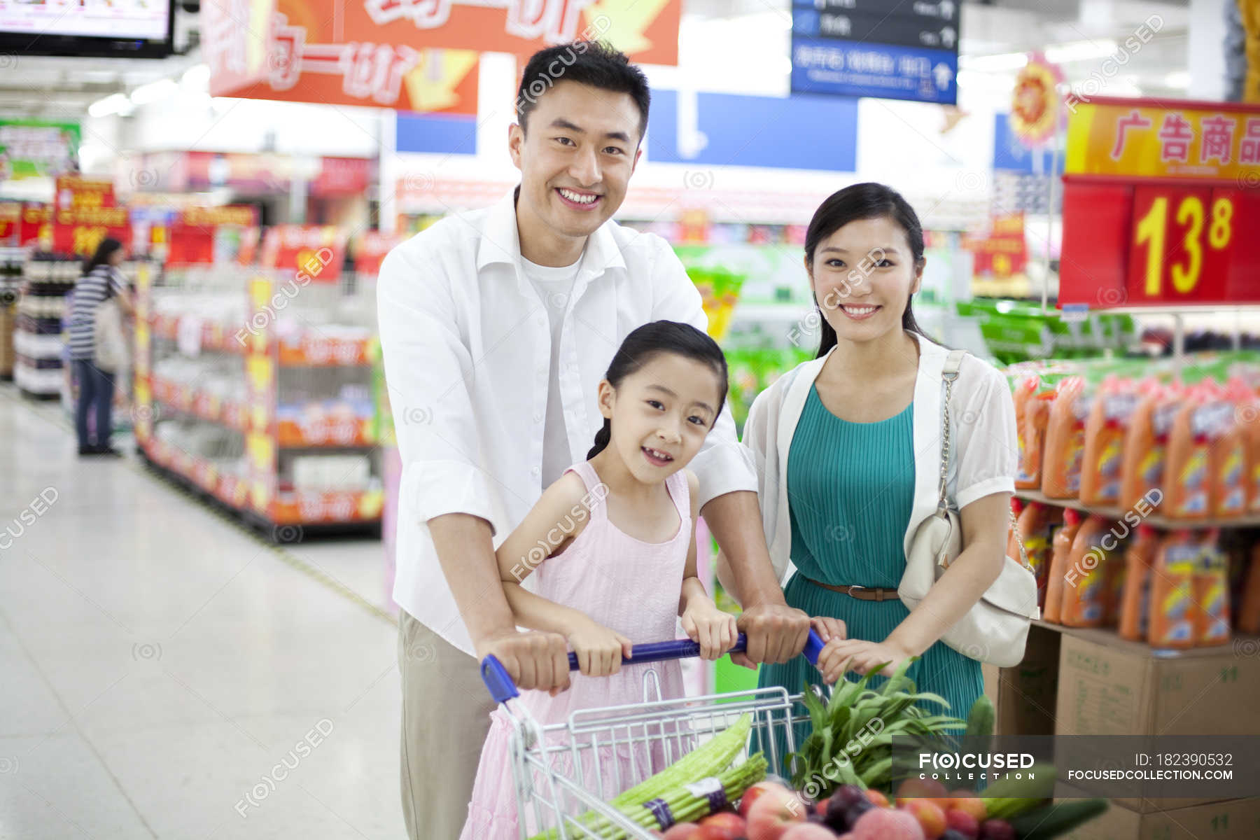Chinese family posing with shopping cart in supermarket — man, Healthy