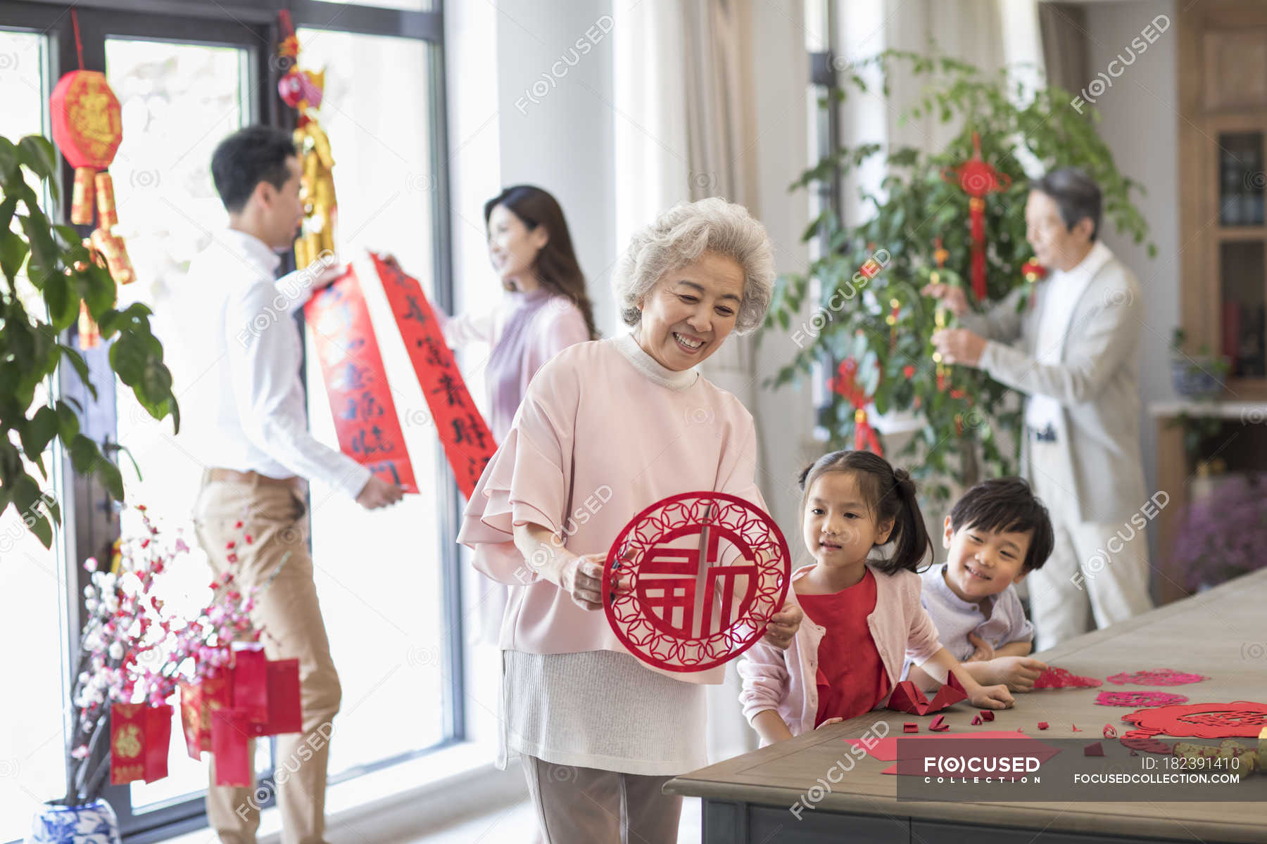Cheerful family decorating home for Chinese New Year — ornaments ...