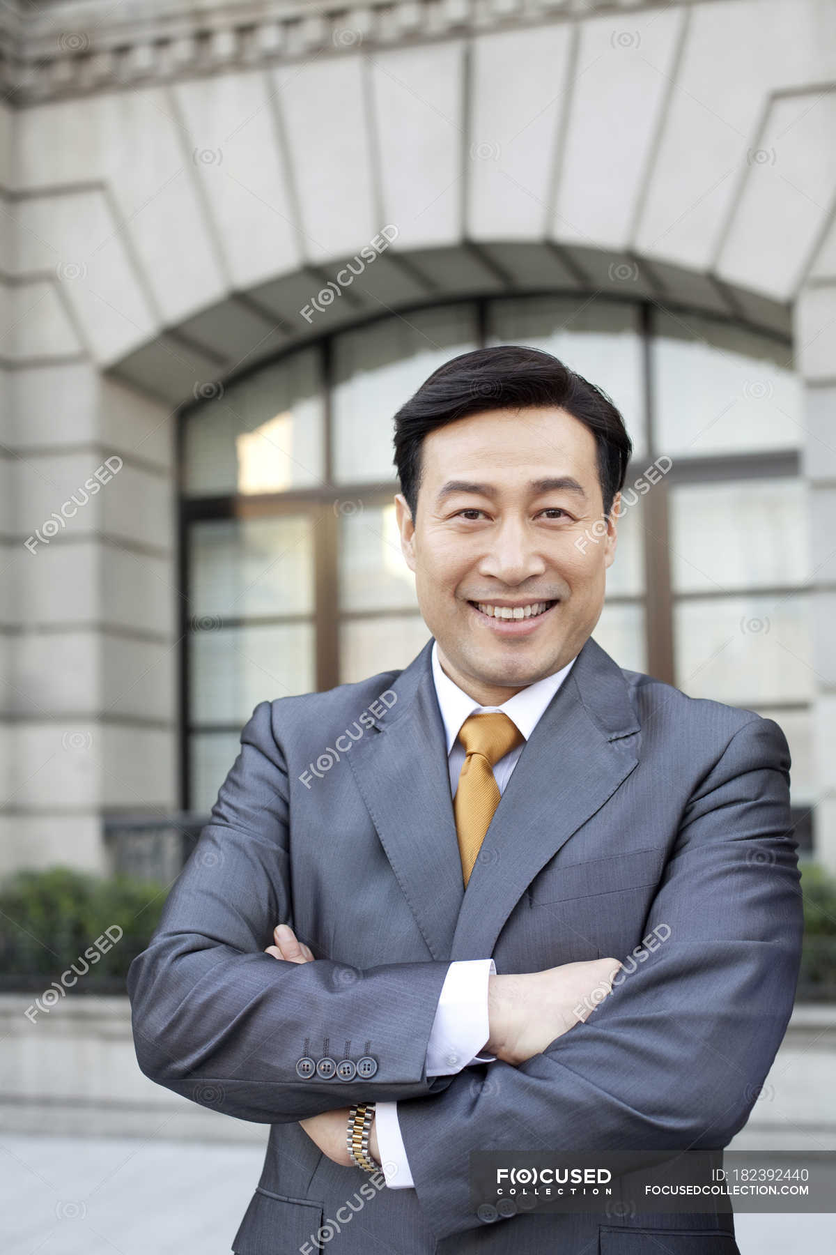 portrait-of-chinese-businessman-with-arms-crossed-in-city-one-person