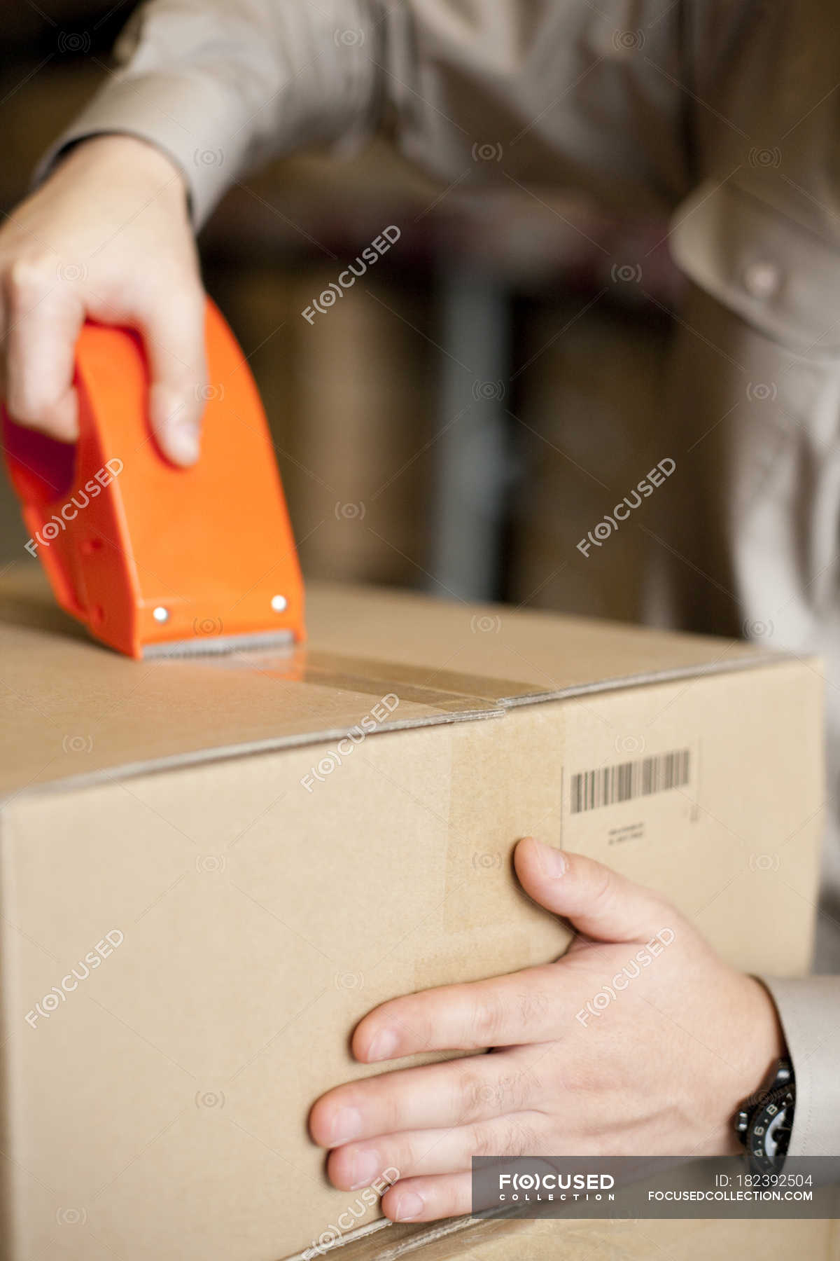 Close Up Of Male Warehouse Worker Packing Box Indoors Cropped   Focused 182392504 Stock Photo Close Male Warehouse Worker Packing 