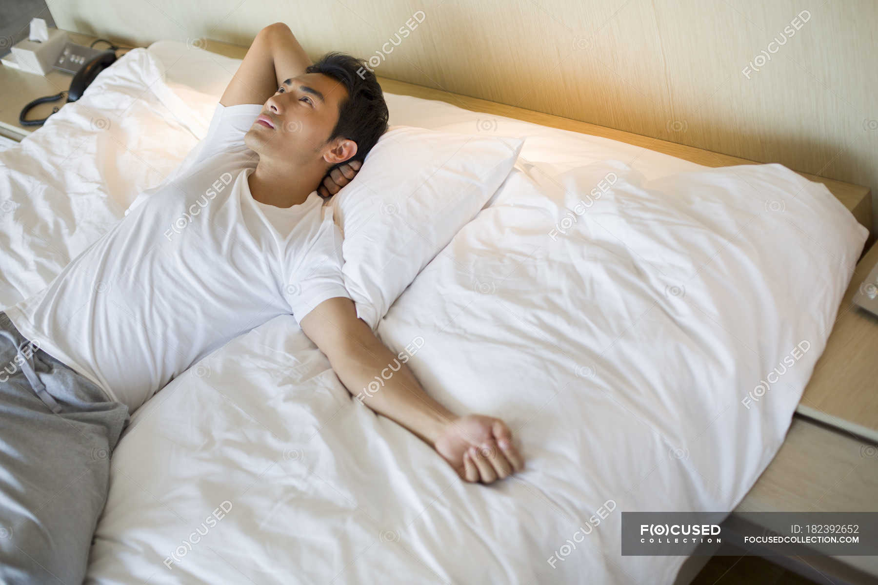 Chinese Man Lying On Bed And Looking Up — Comfortable Lifestyle