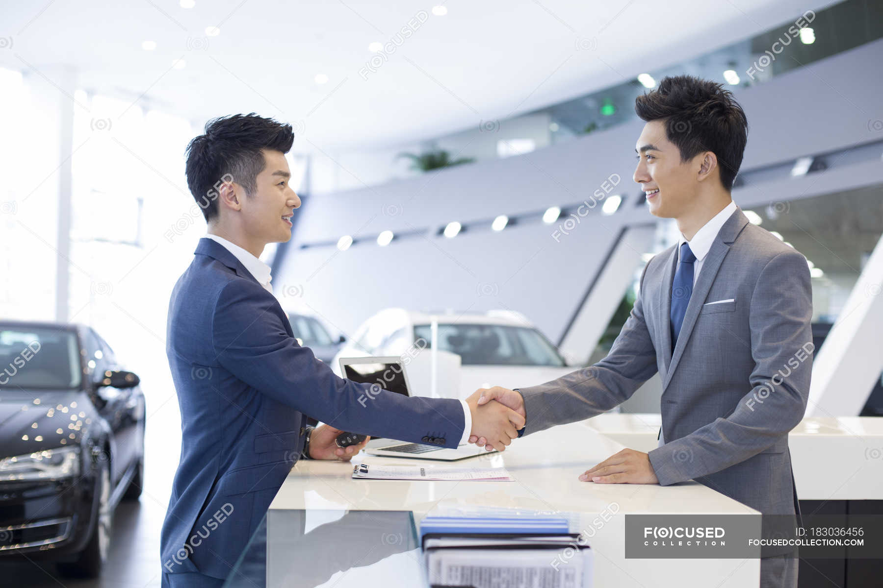 Chinese Man Shaking Hands With Car Dealer In Showroom — Salesperson 