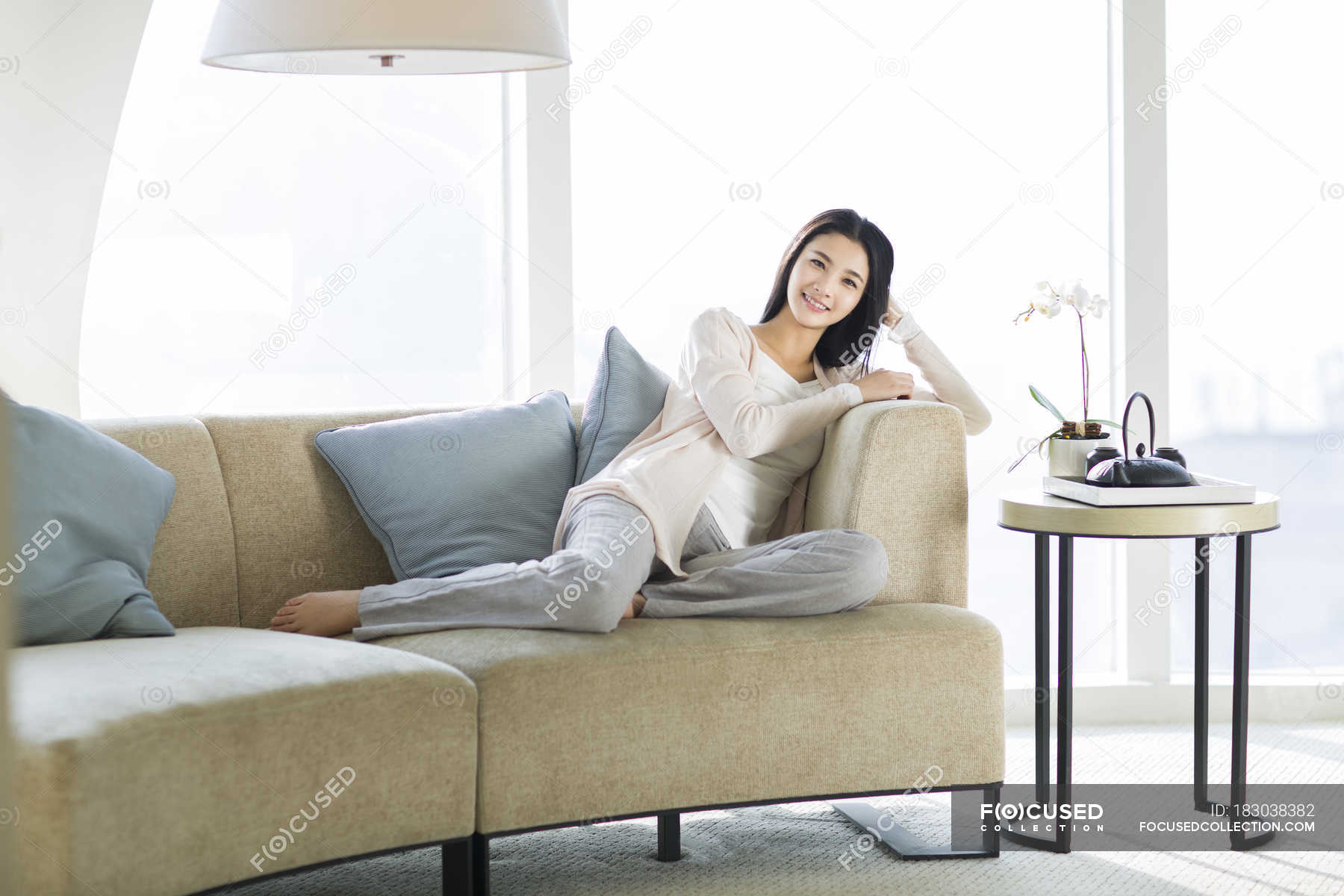 Chinese Woman Sitting On Sofa In Living Room Interior — Backlit One