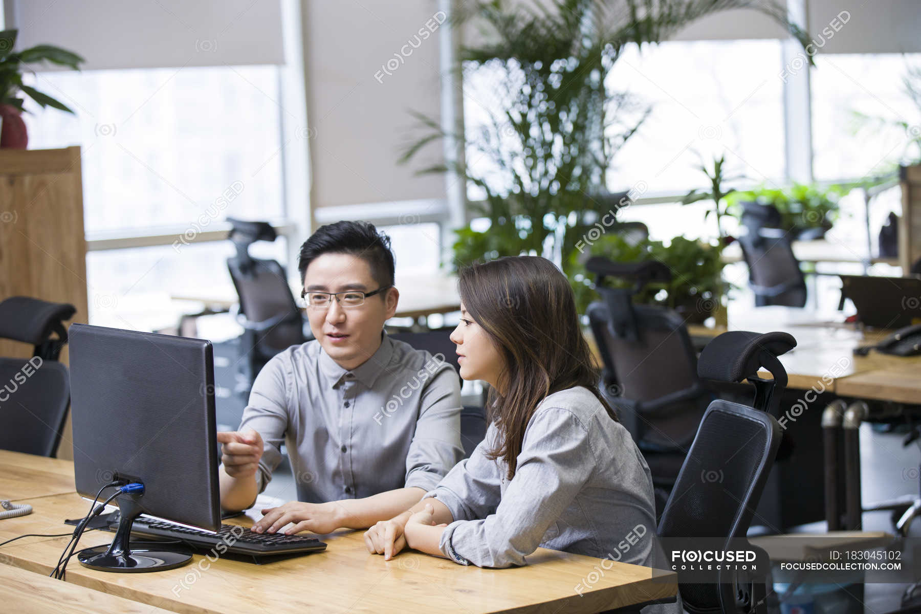 Chinese IT workers using computer in office — co workers, computer ...