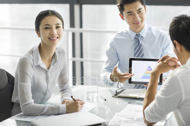 Chinese businessmen discussing presentation on digital tablet in office — Stock Photo