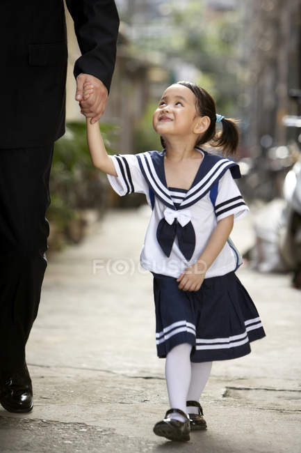 Padre che cammina con la studentessa per strada — Foto stock