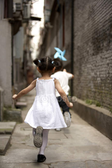 Niños chinos corriendo con molinete de papel - foto de stock