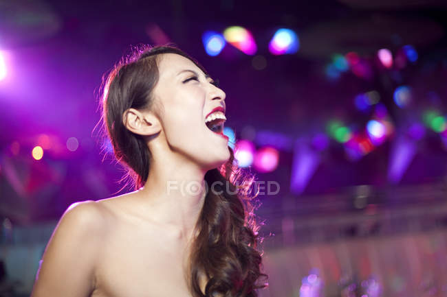 Junge Chinesin lacht in Nachtclub — Stockfoto