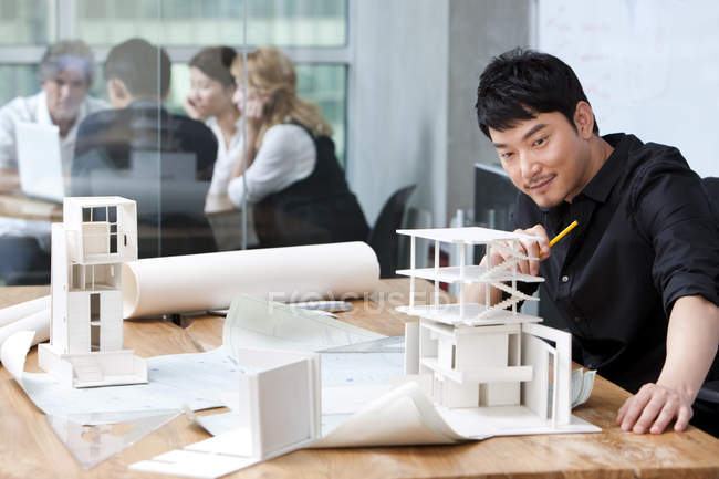 Arquiteto chinês trabalhando com colegas de fundo — Fotografia de Stock