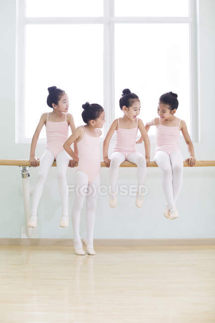 Dançarinos chineses de balé descansando no barre no estúdio de dança — Fotografia de Stock