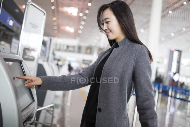 Азіатський жінка за допомогою квитка машини в аеропорту — стокове фото