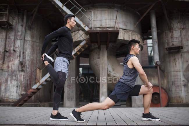 Chinese men stretching on street — Stock Photo