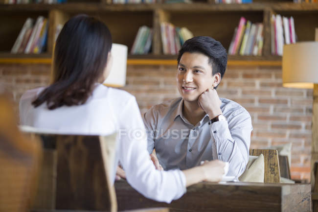 Chino mujer y hombre hablando en la cafetería - foto de stock