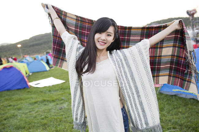 Mujer china sosteniendo bufanda en el festival de camping - foto de stock