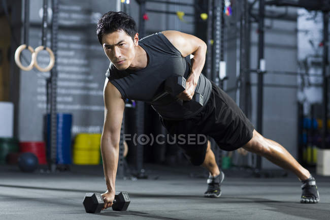 Chinese man training with dumbbells — Stock Photo