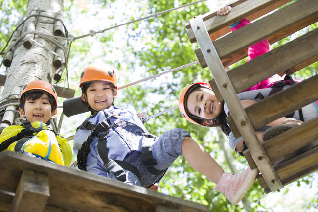 Chinese children posing in tree top adventure park — Stock Photo