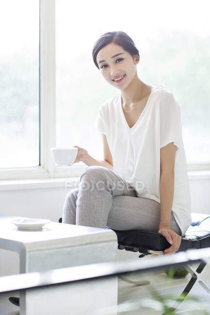 Chinese woman drinking coffee in coffee shop — Stock Photo